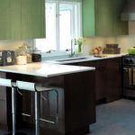 ครัวสีน้ำตาลสีเขียวรอบ ๆ หน้าต่างพร้อมเคาน์เตอร์บาร์แบบคลาสสิก