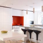 Tablier rouge accent dans une cuisine blanc comme neige