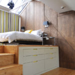 Lit sur le podium dans une chambre avec une lucarne