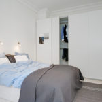 Couvre-lit gris dans le lit de la chambre blanche