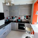 Conception de cuisine avec un comptoir de bar à la place d'une fenêtre de balcon