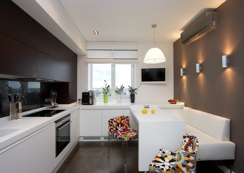 Sofá blanco estrecho en el interior de la cocina con paredes grises.