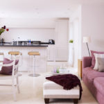 sofá recto con almohadas en la cocina blanca