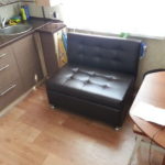 Pequeño sofá cerca de la ventana de una pequeña cocina.