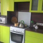 Κουζίνα με μέτωπο ασβέστη και σκούρο πάγκο και ποδιά