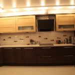 Warm bright kitchen with dark and light wood cabinets looks advantageously illuminated