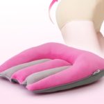 Oreiller rose et gris pour corriger l'ajustement sur une chaise