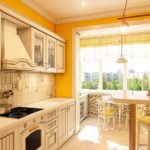 Perabot beige di dapur dengan dinding kuning.