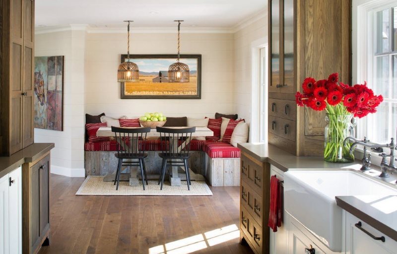 Fleurs rouges sur un rebord de fenêtre de cuisine avec coin