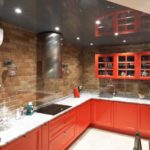 ผ้ากันเปื้อนครัวอิฐแดงรวมกับท็อปครัวหินสีเทาและซุ้มสีแดงเข้ม