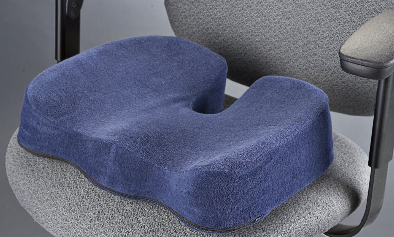 Oreiller orthopédique bleu marine sur une chaise de bureau