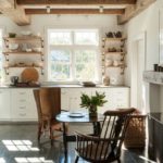 Silla de madera con respaldo delante de la mesa redonda.