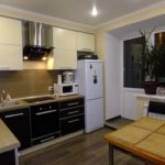Photo of a kitchen with a fridge by the window