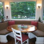 Two decorative pillows on a sofa in a bay window