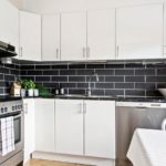 Costuras blancas entre azulejos grises.