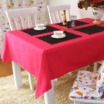 Serviettes noires pour la vaisselle sur une nappe rouge