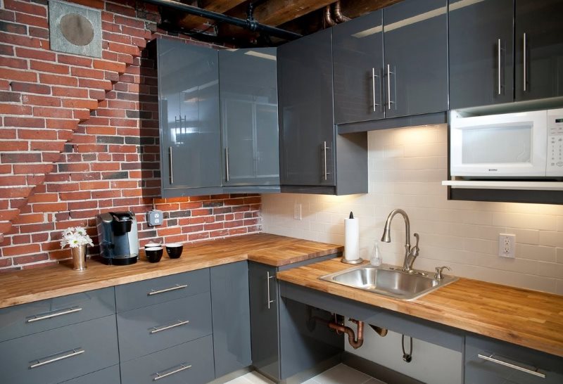 Delantal beige en la cocina con pared de ladrillo.