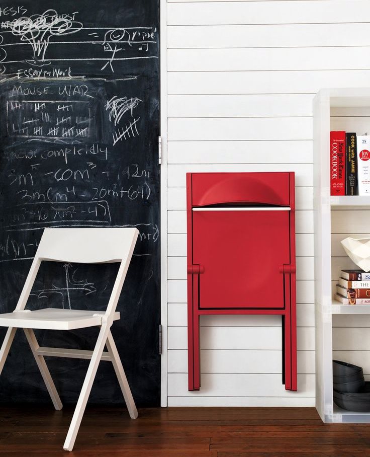 Scaun pliant roșu pliat pe perete