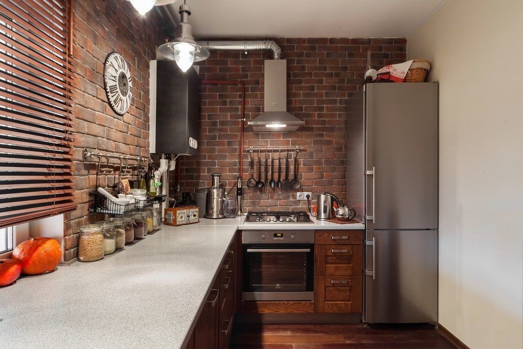 small loft style kitchen with brick wall