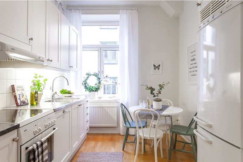 Weiße Möbel in schmaler skandinavischer Küche