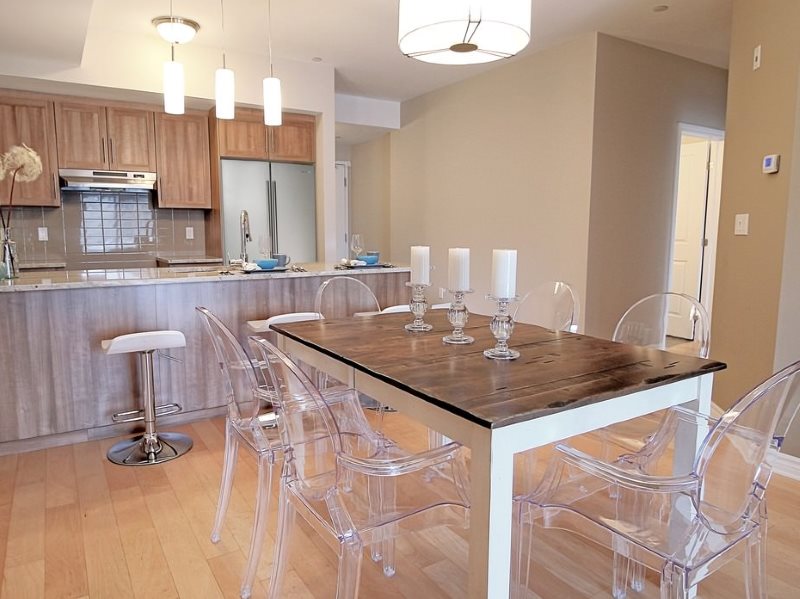 Transparent chairs in a small kitchen of a city apartment