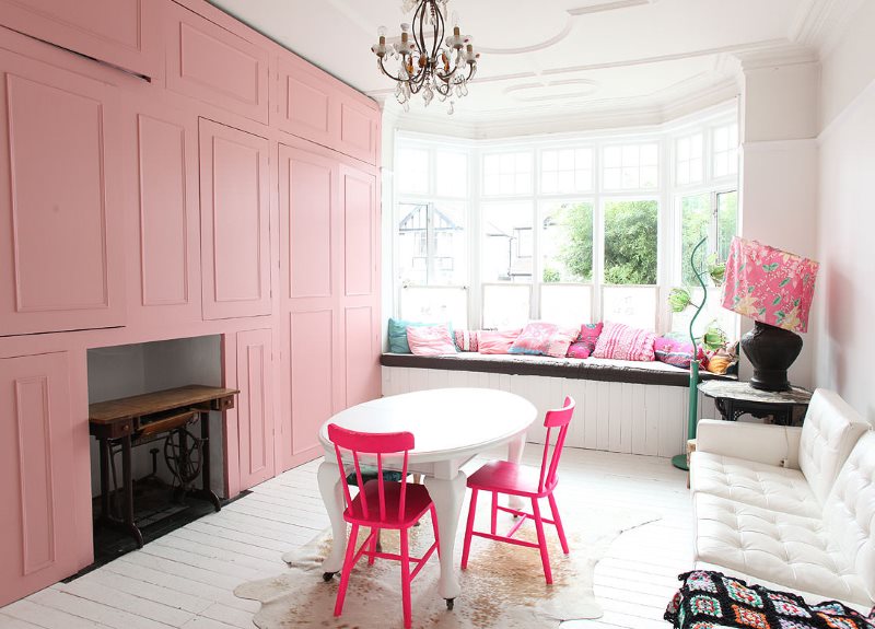 Pink chairs around a white oval shaped table