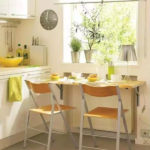 Mică masă în fața ferestrei bucătăriei