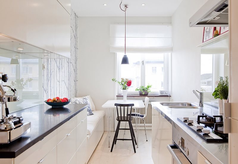 Essbereich in der schmalen Küche mit Sofa an der Wand