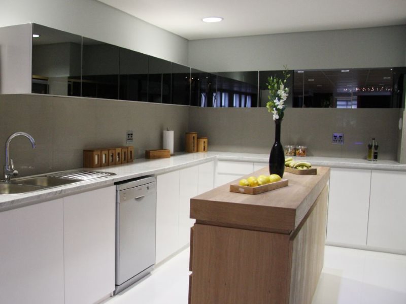 Fachadas negras de armarios colgantes con una superficie brillante.