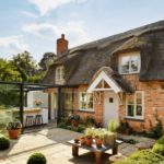 Καλοκαιρινή κουζίνα από γυαλί κοντά στο σπίτι από τούβλα