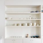 Бели рафтове в нишата на стената на кухнята