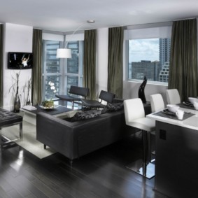The interior of the kitchen-living room with dark furniture