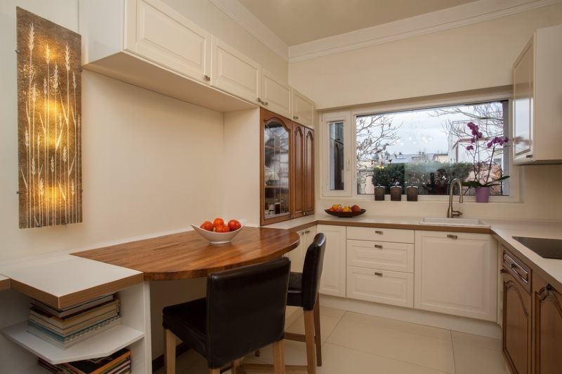 Sillas de color chocolate en la cocina con mesa de madera.