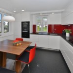 Κόκκινη καρέκλα στην κουζίνα με λευκές προσόψεις