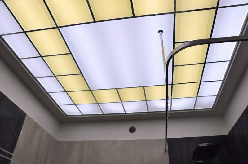 Hermoso techo de paneles acrílicos en un baño pequeño.