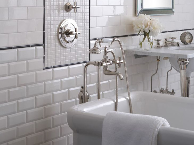 Brilliant faucet on the background of a white wall made of boar tiles