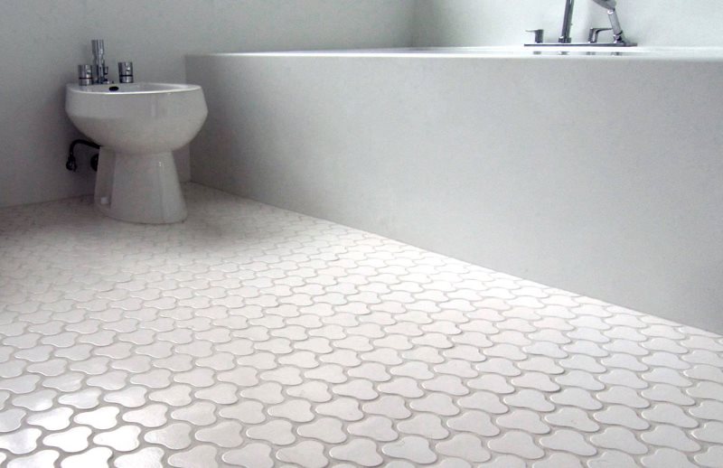 Carreaux de céramique blanche sur le plancher chaud de la salle de bain