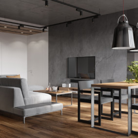 Sofá gris en una habitación con paredes de hormigón.