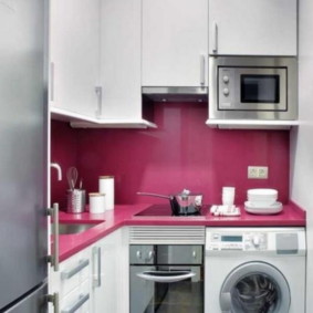 Apron merah jambu di dapur dengan mesin basuh