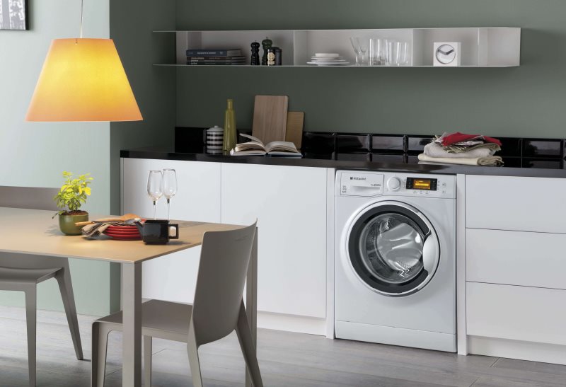 White washing machine under the countertop of the kitchen set