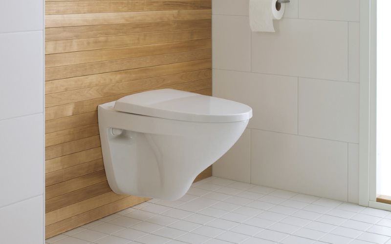Toilette suspendue blanche sur un mur en bois