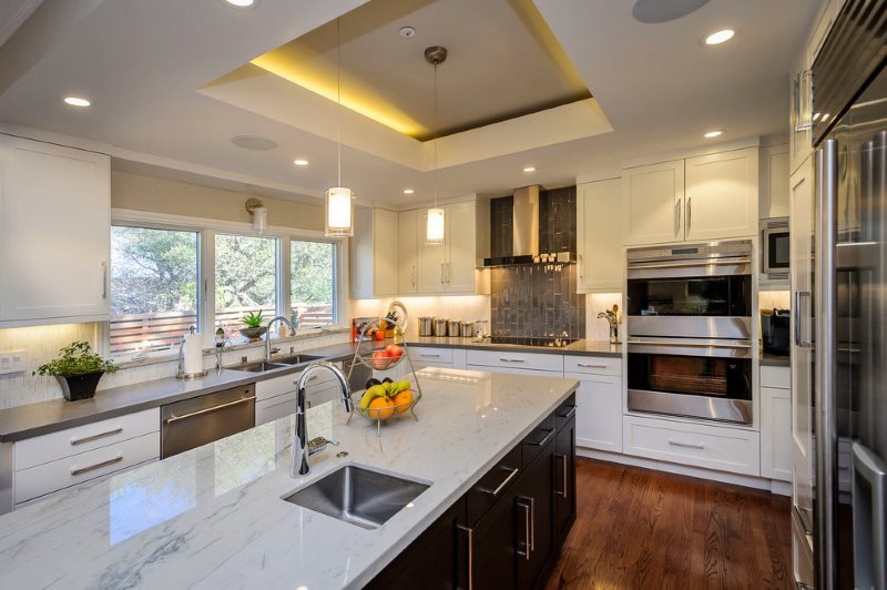 Backlit stretch ceiling in the kitchen with island