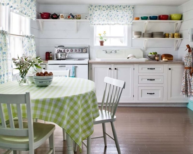 Toalha de mesa quadriculada na cozinha com prateleiras brancas.