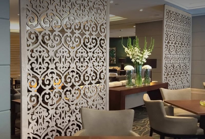 Zoning of the kitchen-living room with carved panels