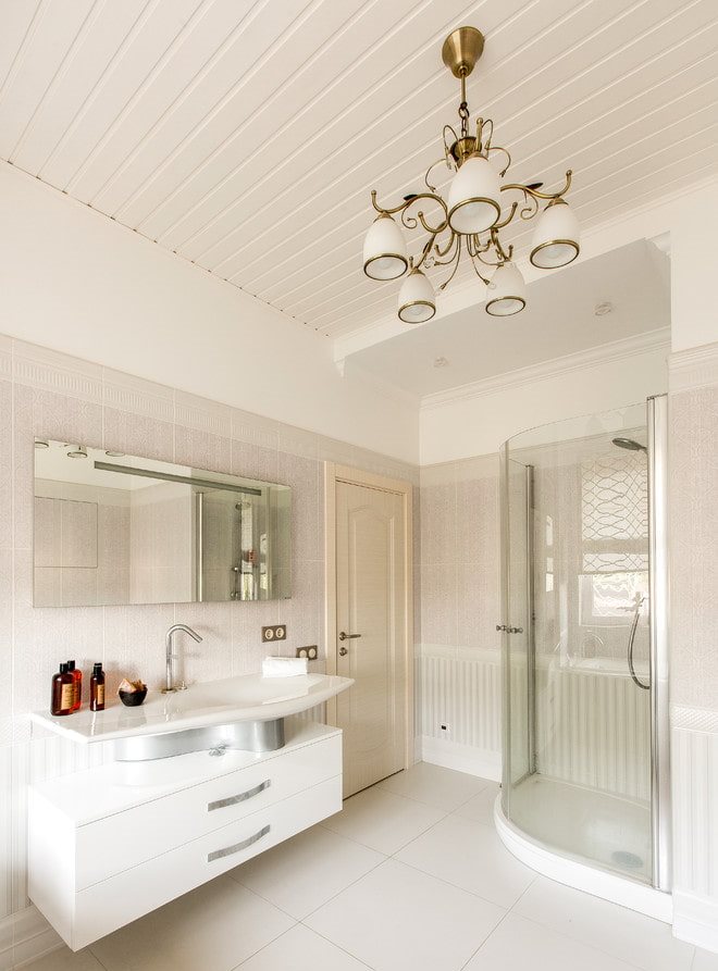 Paneles de plástico en el techo con una lámpara de araña.