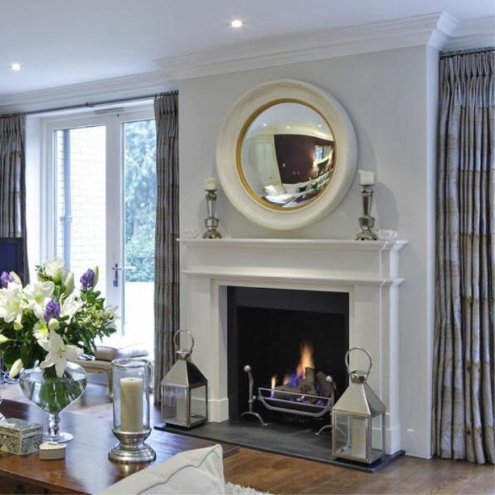 Cermin bulat besar di atas perapian di ruang tamu