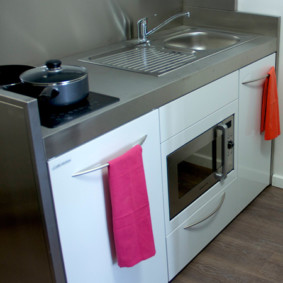 Handuk merah jambu pada pemegang mesin basuh pinggan mangkuk