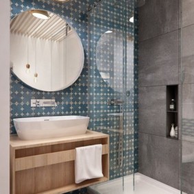 Round rimless mirror over a white sink