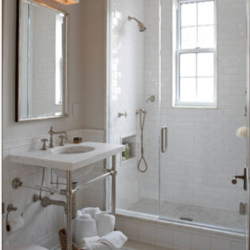 Coș cu prosoape albe pe podeaua băii