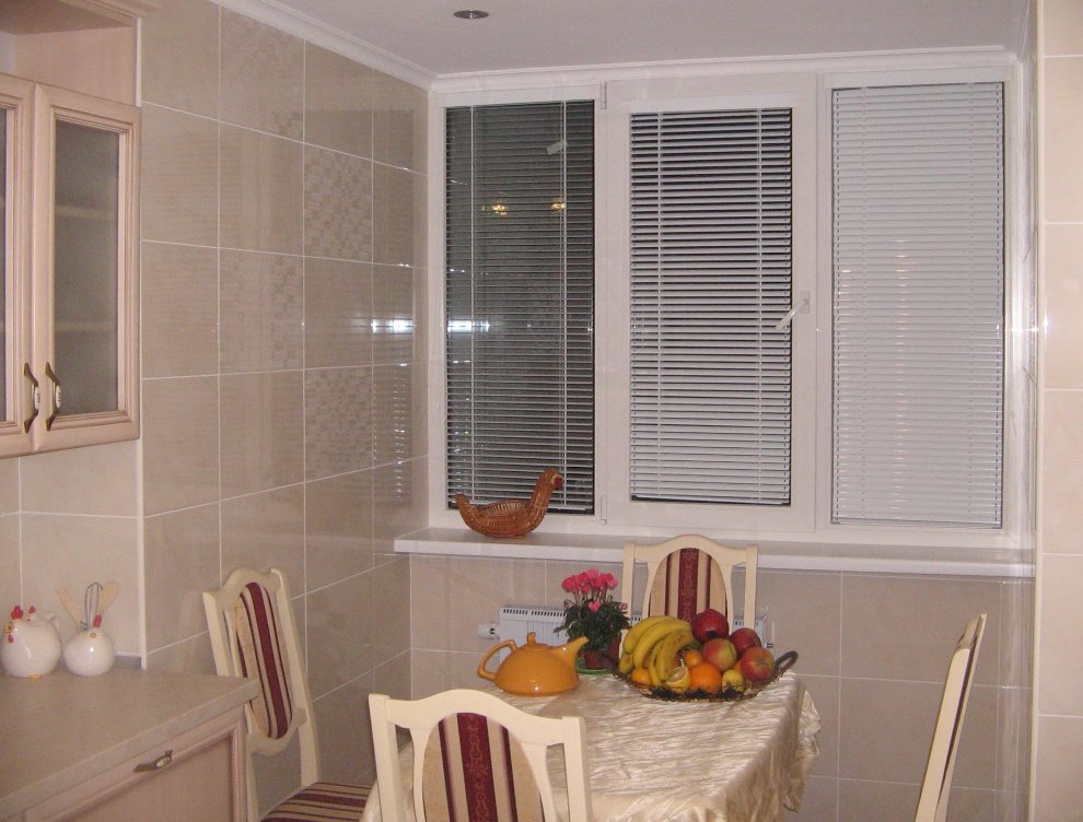Jaluzele cu casetă albă pe o fereastră din bucătărie din plastic